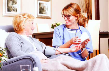 nurse getting the blood pressure level of senior woman