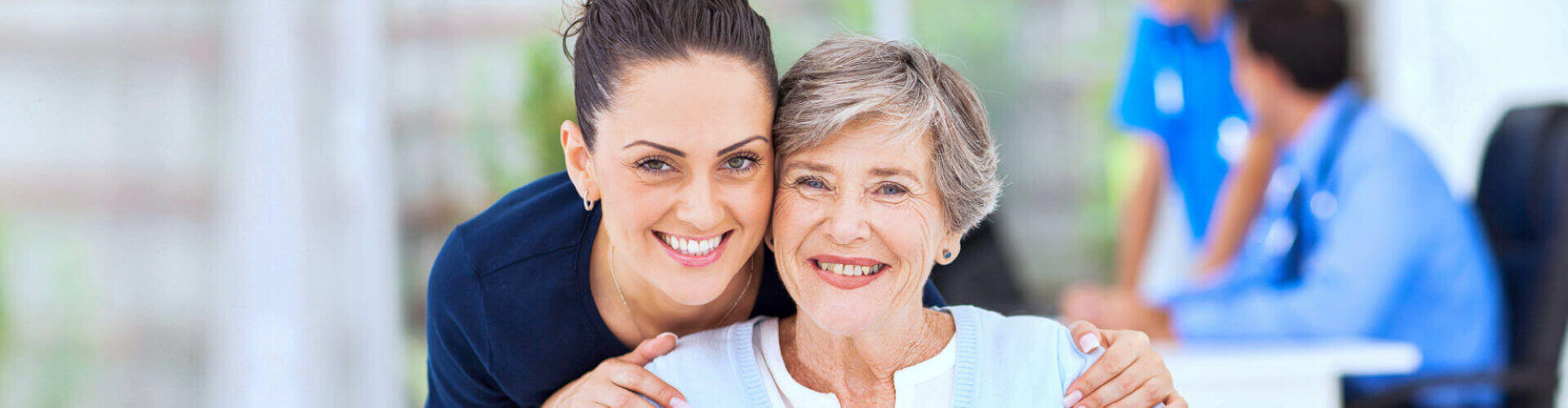 nurse and senior woman are smiling at the hospital