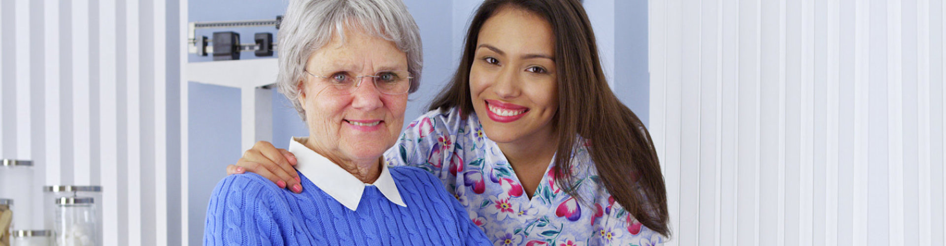 caregiver and senior woman are smiling at the hospital