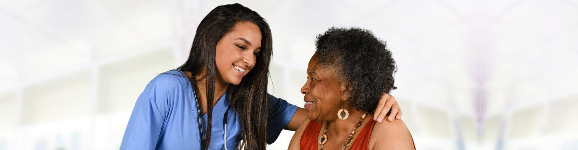 nurse and senior woman are smiling together