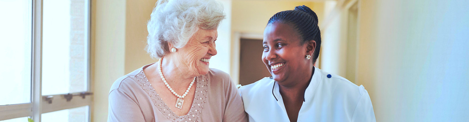 nurse and senior woman are walking at the hallway